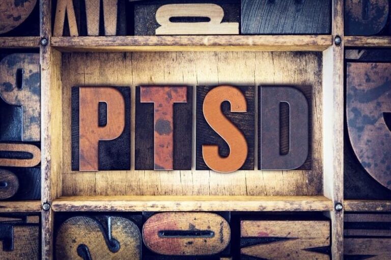 Wooden letterpress blocks spelling the word PTSD