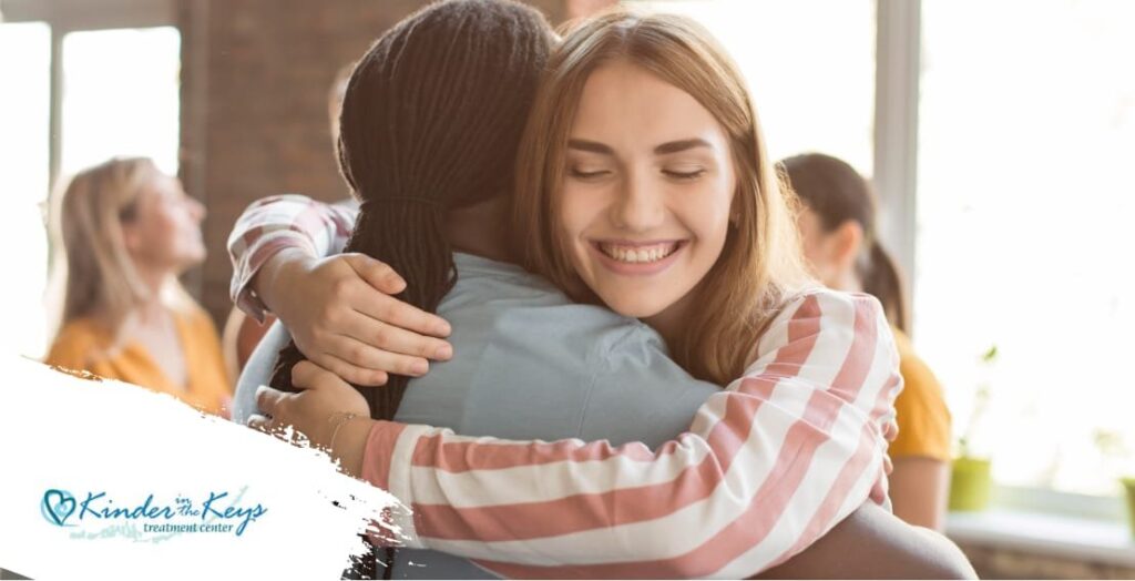 Two people embracing in a warm, supportive environment, symbolizing safety, connection, and healing in trauma-informed mental health care.