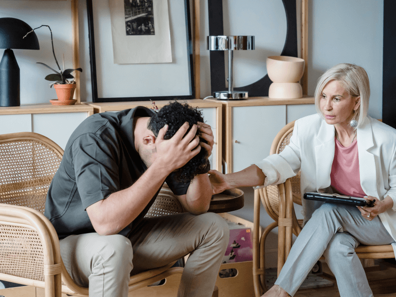 A depressed man getting consoled by his therapist