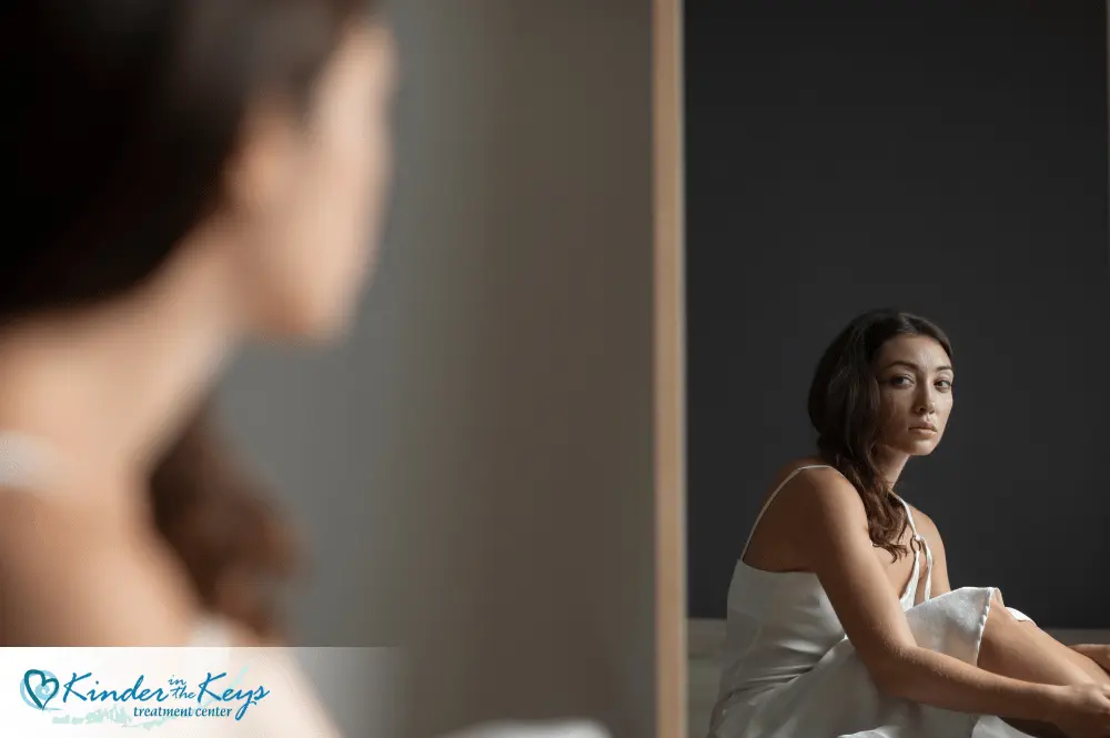 Woman with anxiety depression PTSD from narcissistic abuse reflected in mirror.