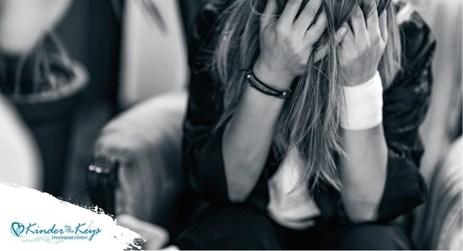 Woman in distress holding head, symbolizing PTSD from narcissistic abuse.